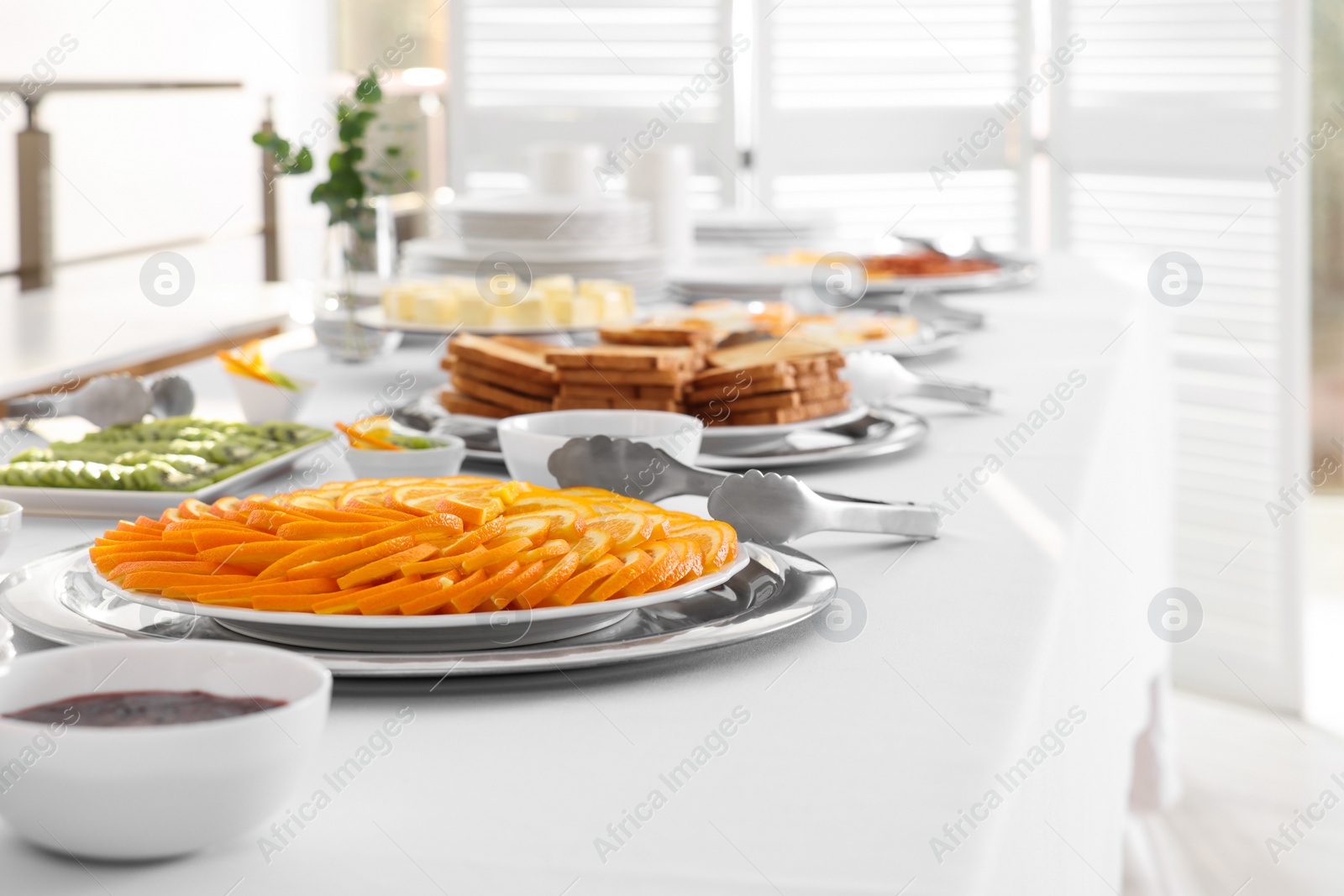 Photo of Different meals for breakfast on white table indoors. Buffet service