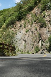 Asphalt road with yellow line near mountains outdoors