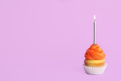 Photo of Birthday cupcake with candle on violet background, space for text