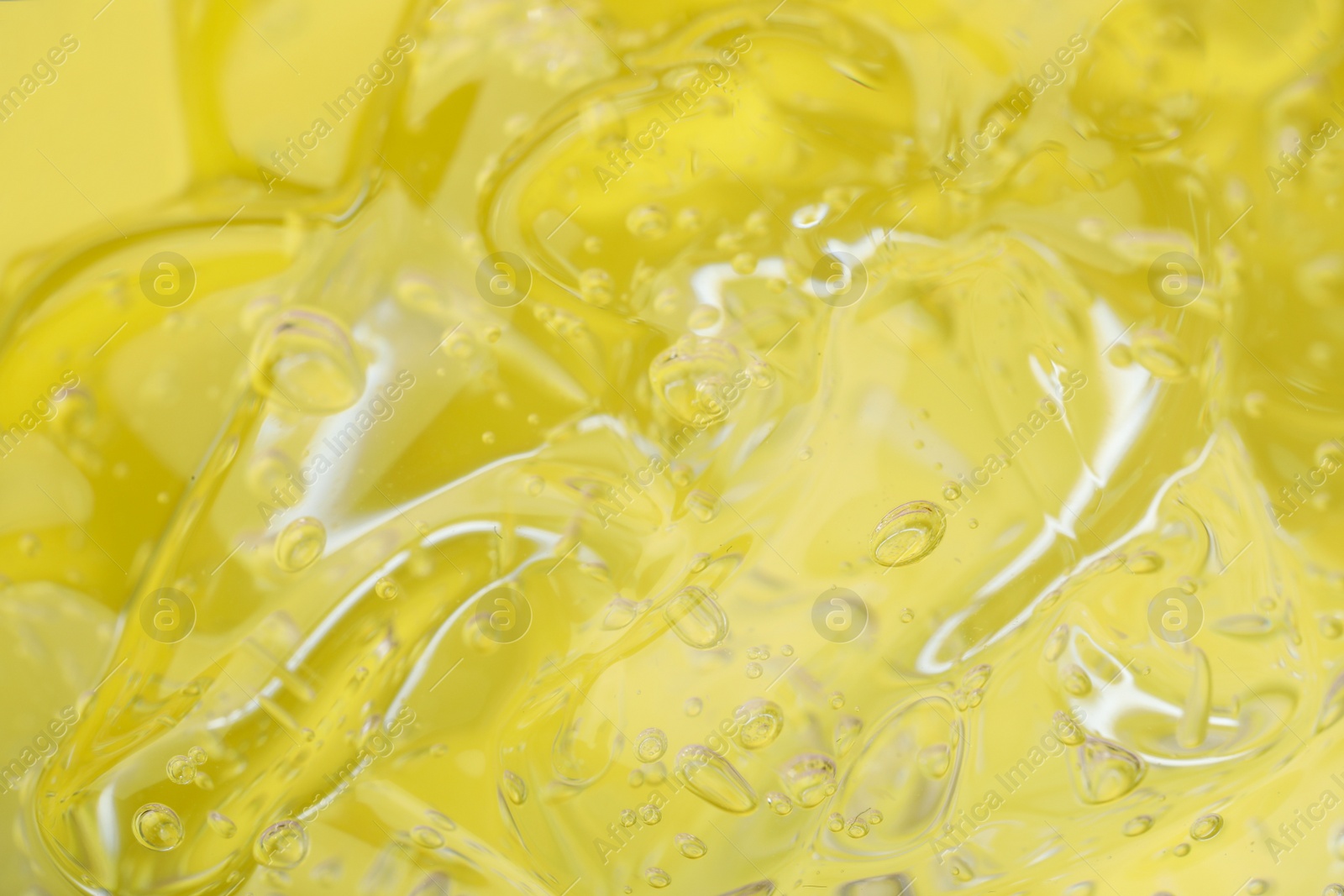 Photo of Pure transparent cosmetic gel on yellow background, closeup