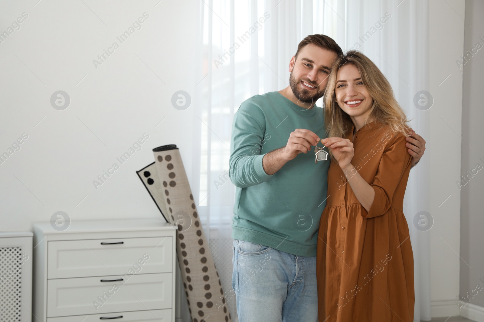 Photo of Happy young couple with key in new house. Space for text