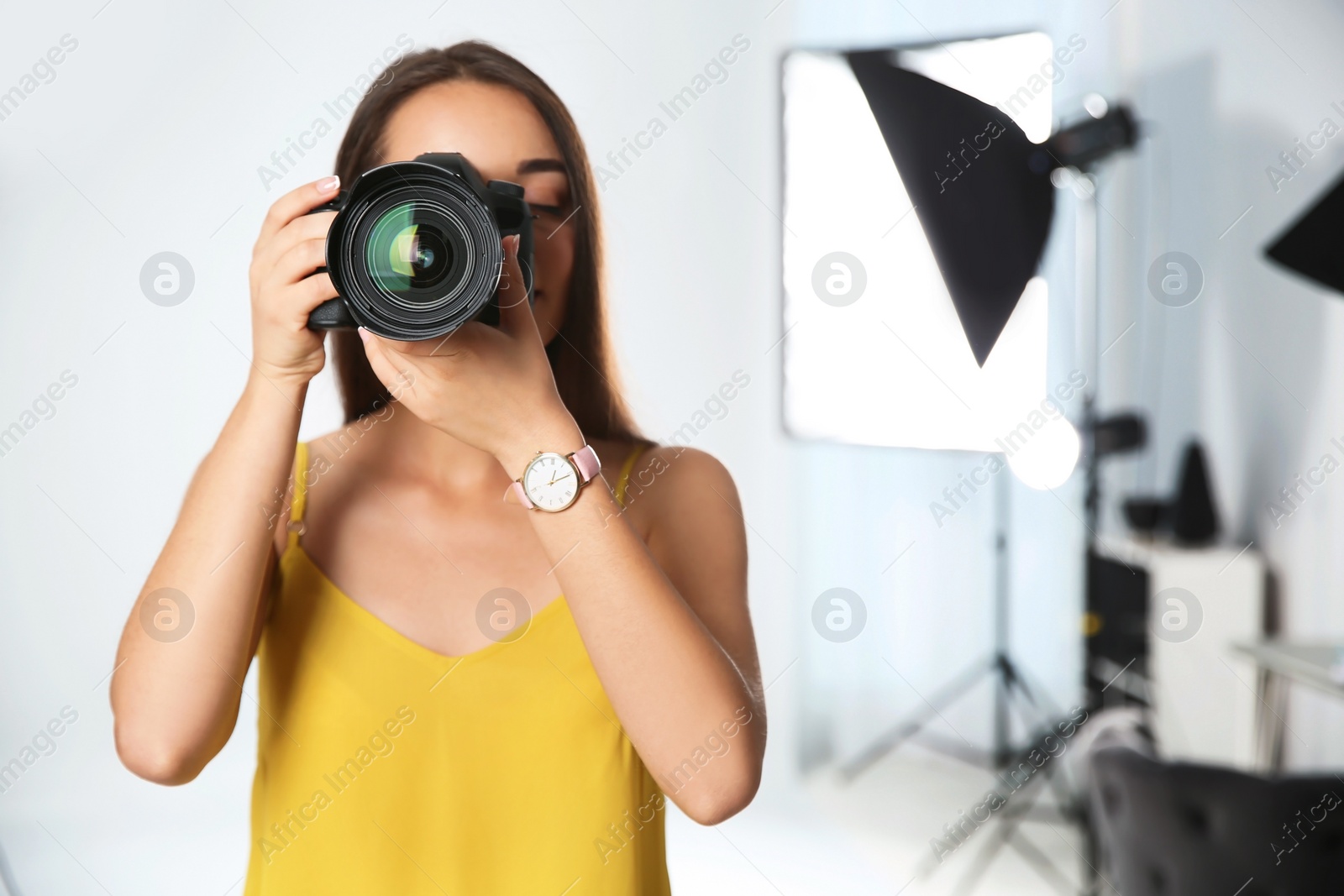 Photo of Professional photographer with camera in photo studio