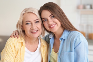 Portrait of young woman with her mature mother indoors