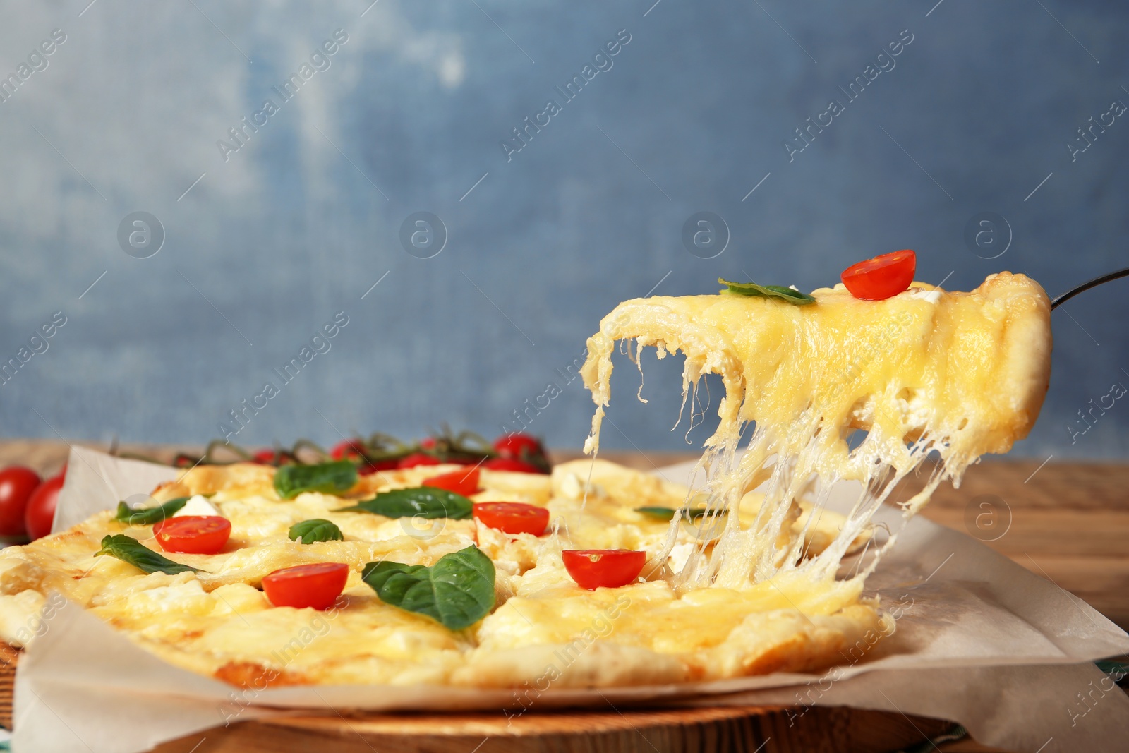 Photo of Taking tasty homemade pizza slice with melted cheese on table