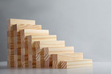 Photo of Steps made with wooden blocks on light background, space for text. Career ladder