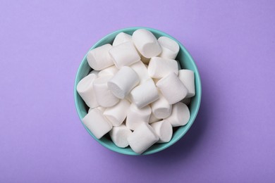 Photo of Delicious puffy marshmallows on lilac background, top view