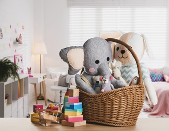 Image of Set of different cute toys on wooden table in children's room