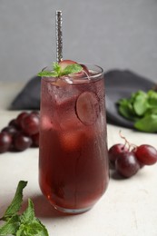 Photo of Delicious grape soda water with mint on white table. Refreshing drink