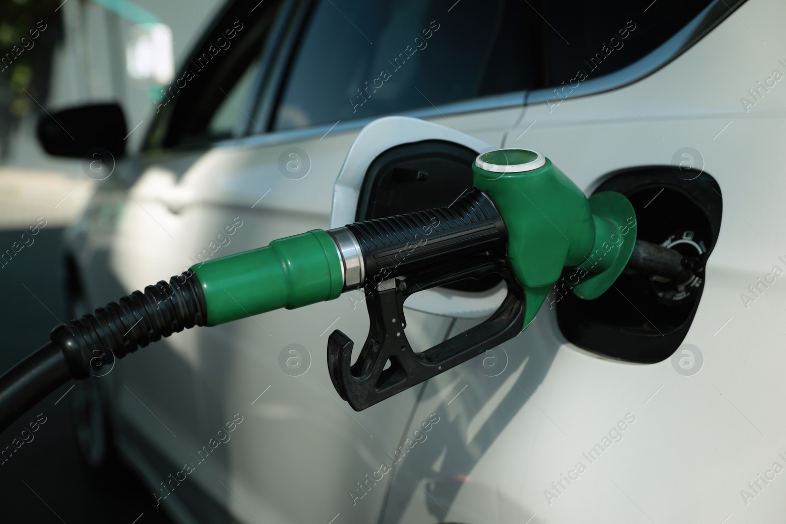 Photo of Refueling modern car with petrol pump on gas station, closeup