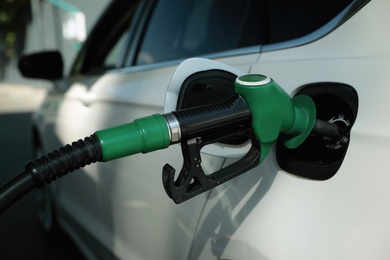 Refueling modern car with petrol pump on gas station, closeup