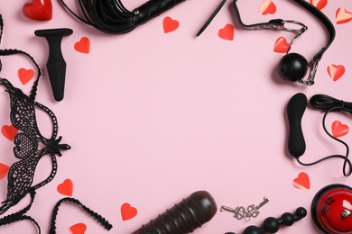 Frame made of different sex toys on pink background, flat lay. Space for text