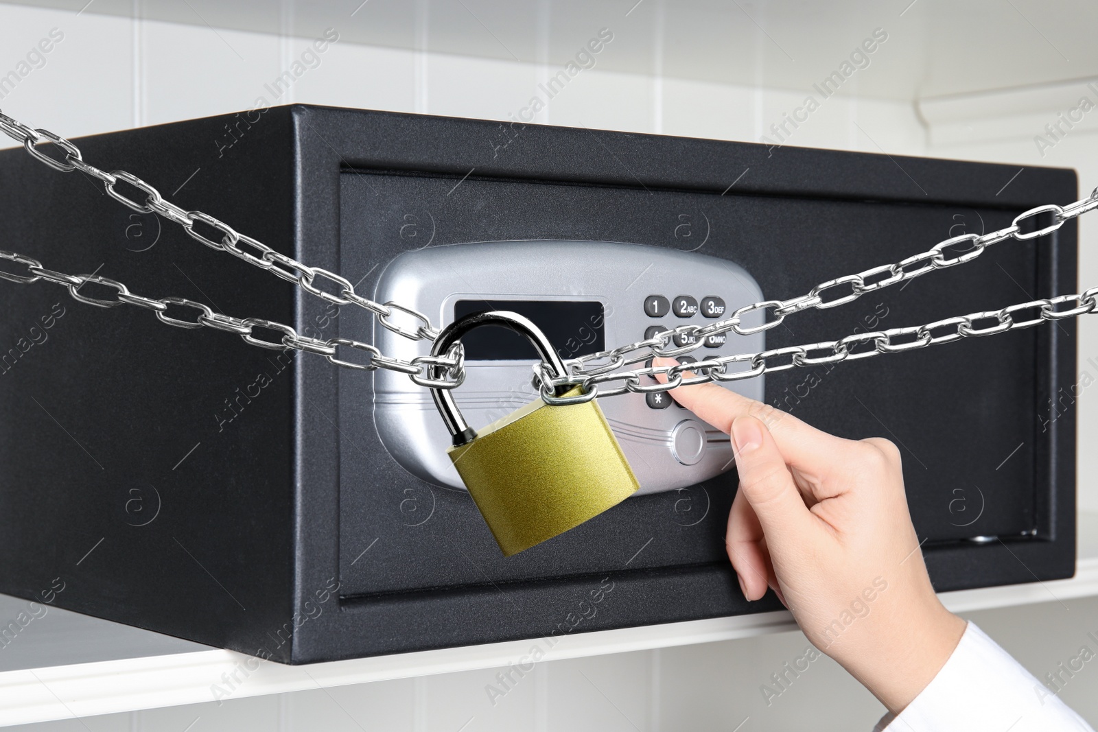 Image of Woman opening steel safe with electronic lock, closeup