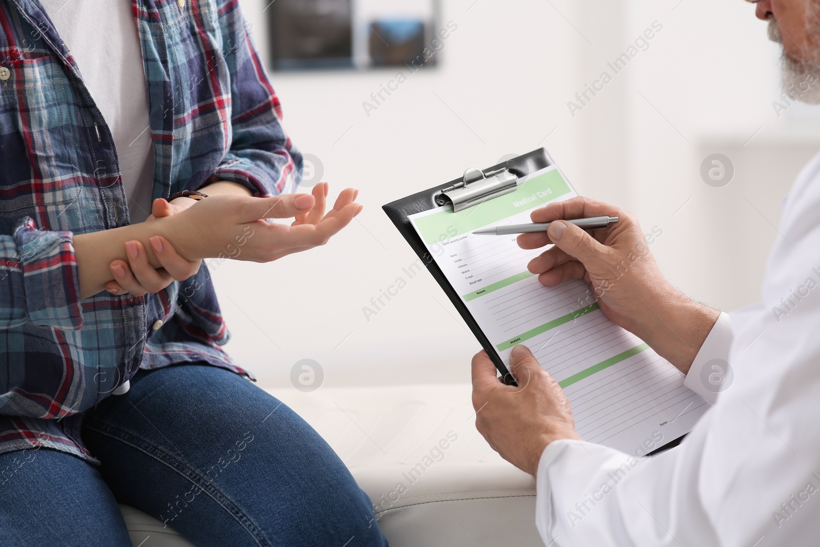 Photo of Doctor filling patient's medical card in clinic, closeup