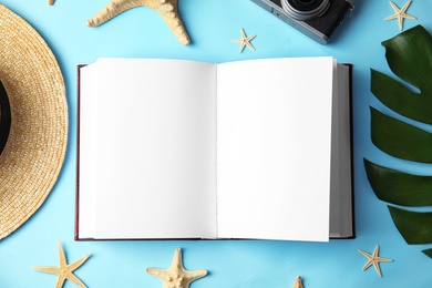 Flat lay composition with open hardcover book on light blue background