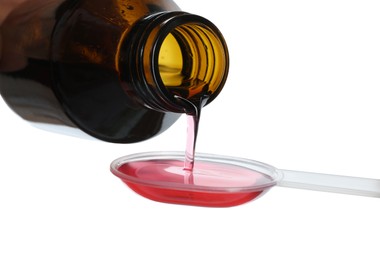 Photo of Pouring cough syrup into dosing spoon on white background