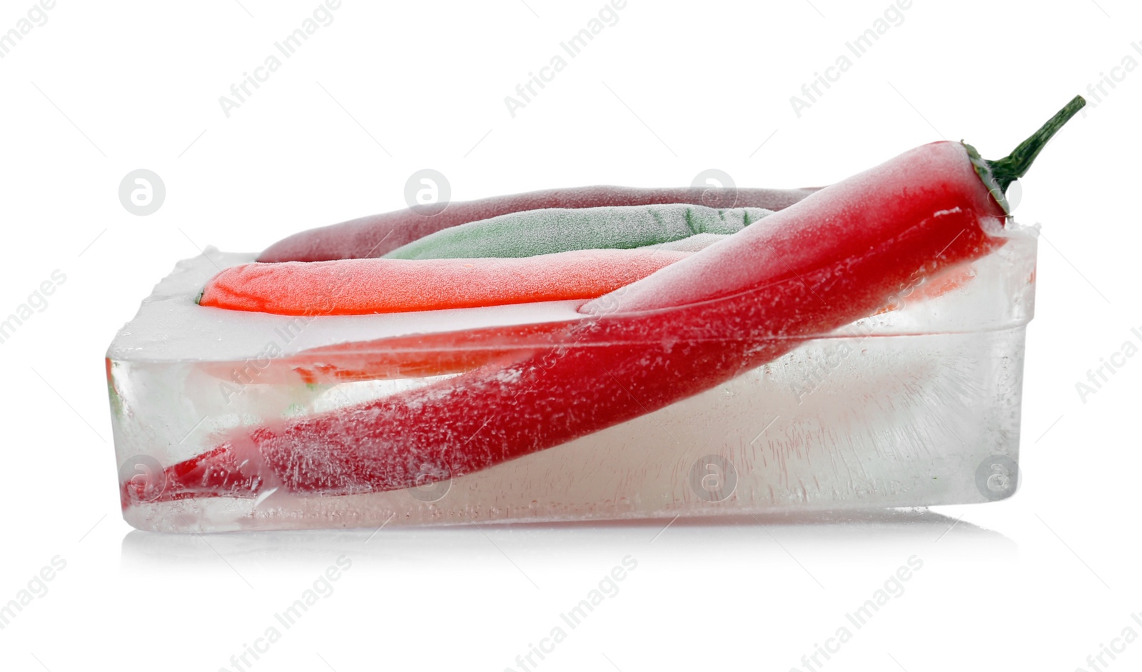 Photo of Chili peppers in ice cube on white background. Frozen vegetables