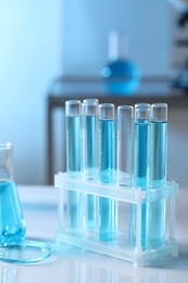 Test tubes with light blue liquid in laboratory, closeup