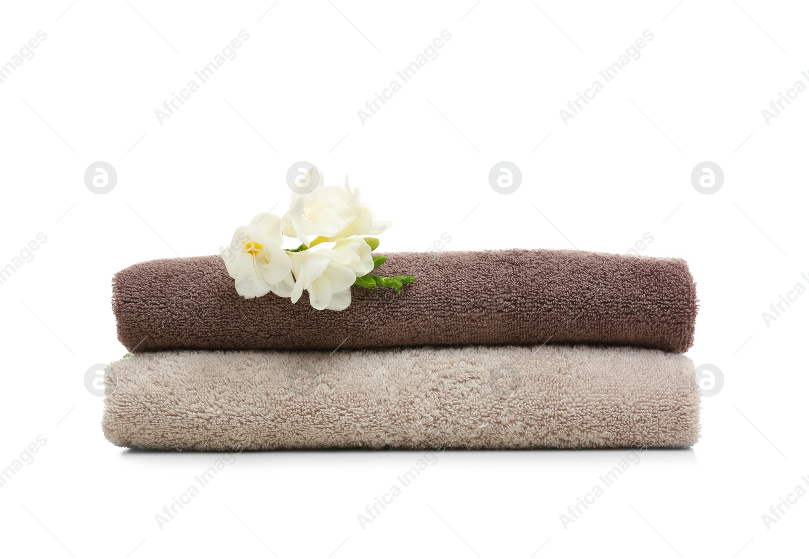 Photo of Clean folded towels with flowers on white background