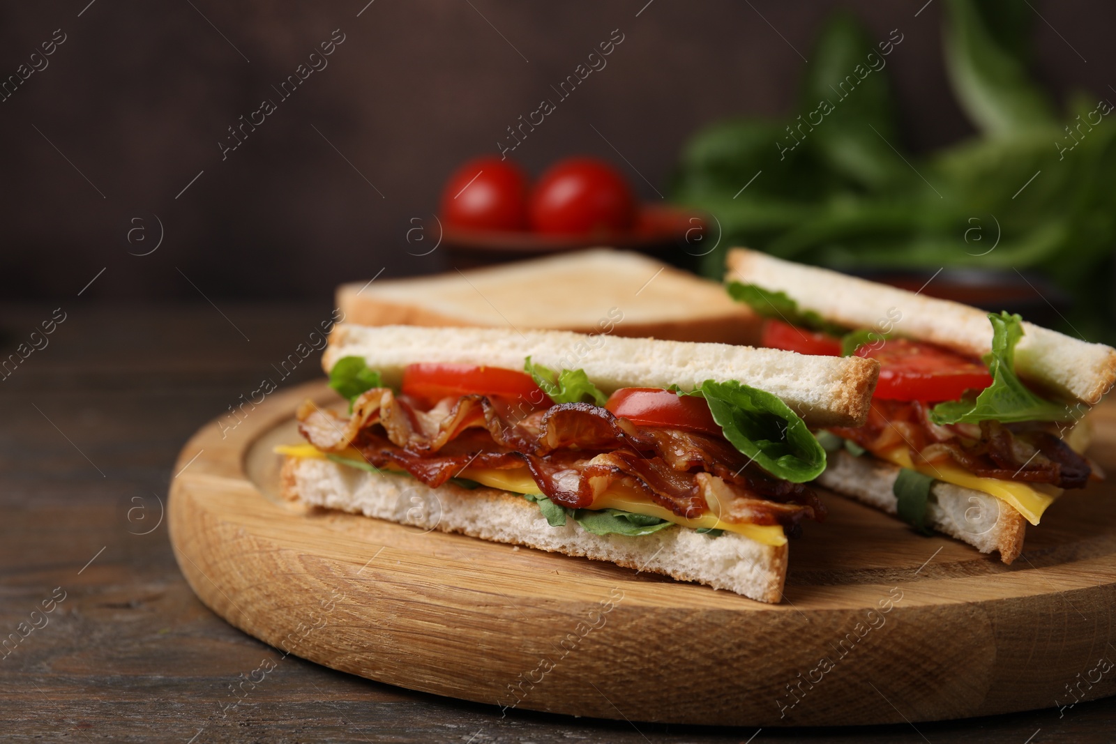Photo of Delicious sandwiches with fried bacon on wooden table, closeup
