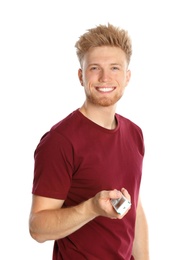 Young man with air conditioner remote on white background