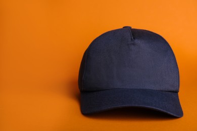 Photo of Baseball cap on orange background, space for text