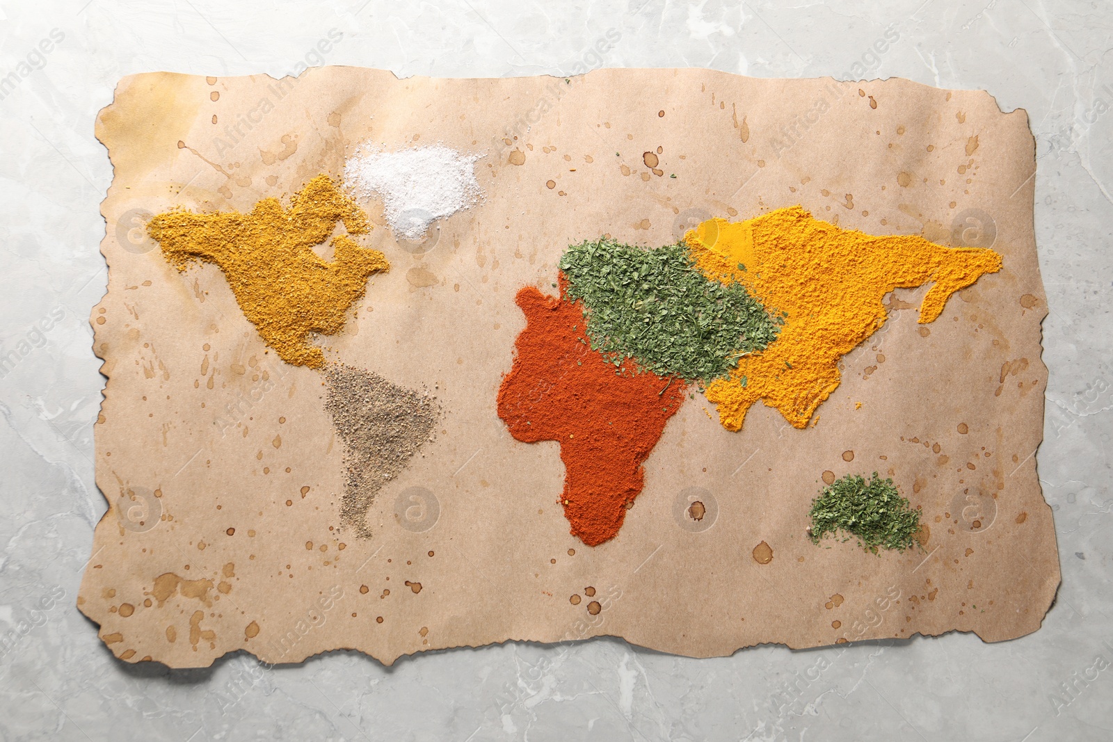 Photo of World map of different spices on light grey marble table, top view