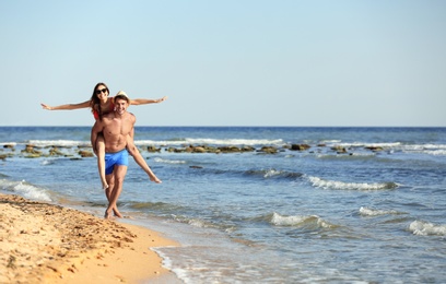 Photo of Happy young couple having fun at beach on sunny day