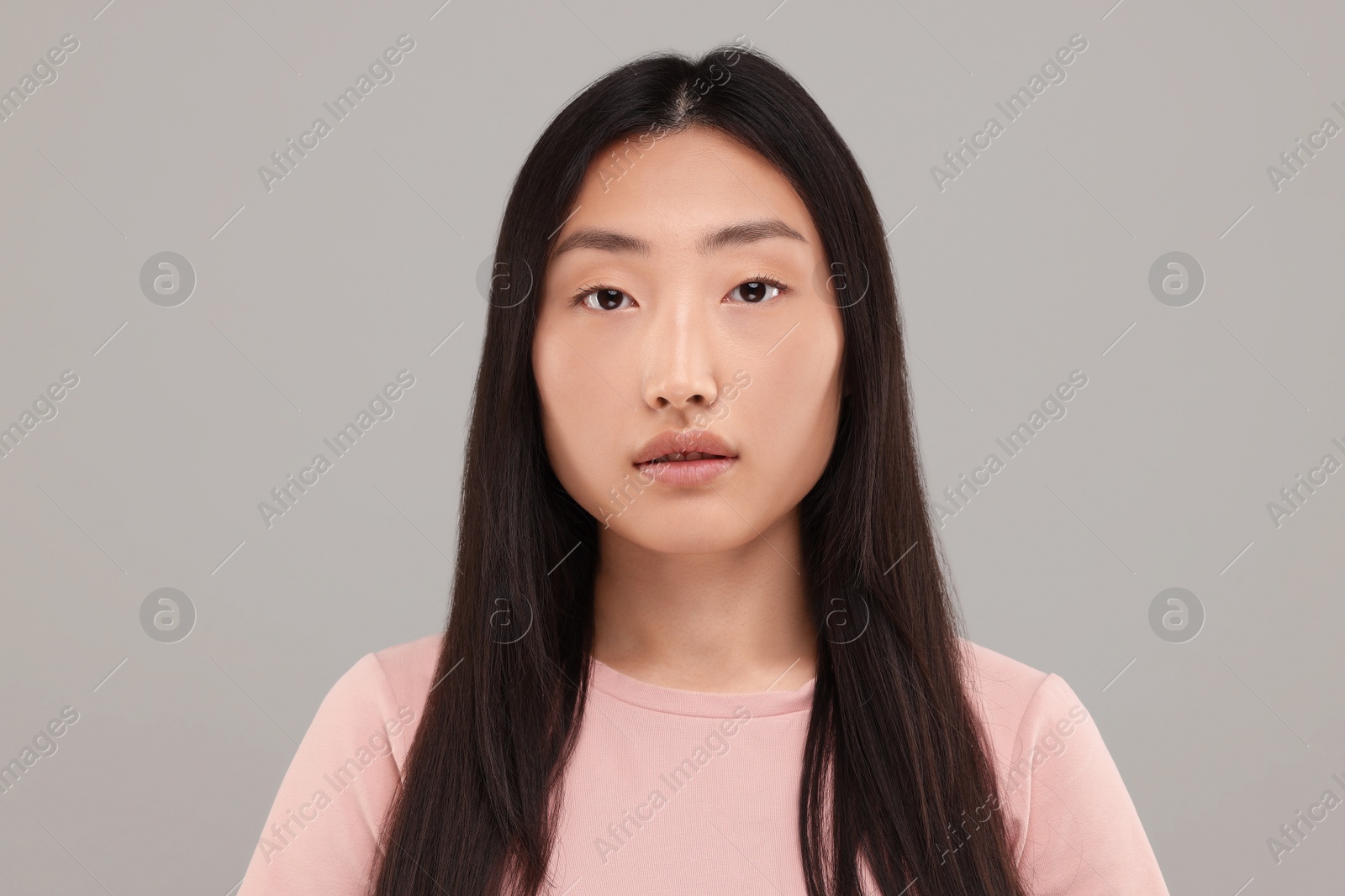 Photo of Portrait of beautiful young woman on grey background