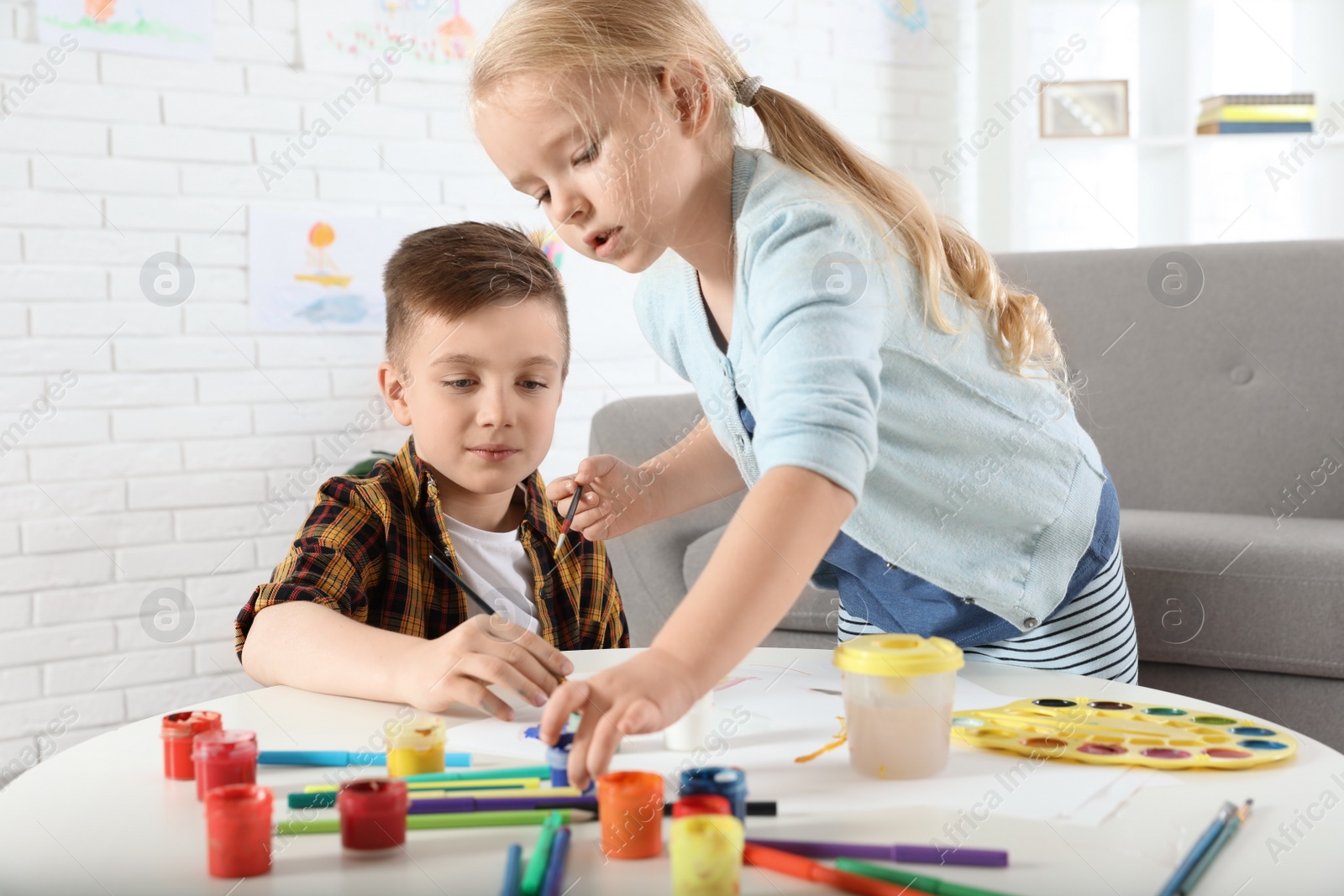 Photo of Cute little children painting together at home