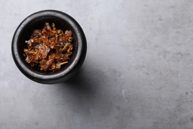 Photo of Modern hookah bowl with tobacco on grey table, top view. Space for text