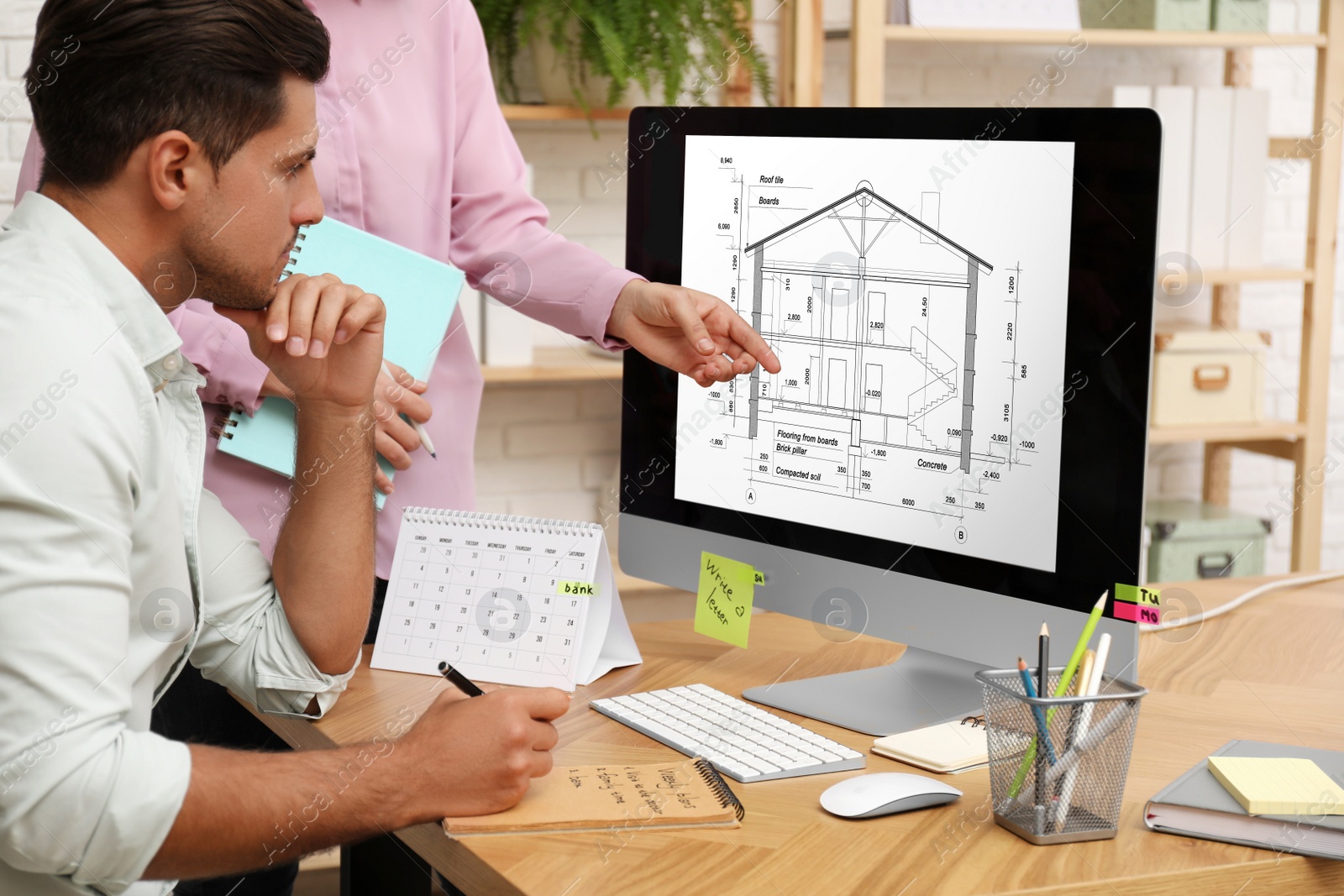 Image of Architects making project of house on computer in office