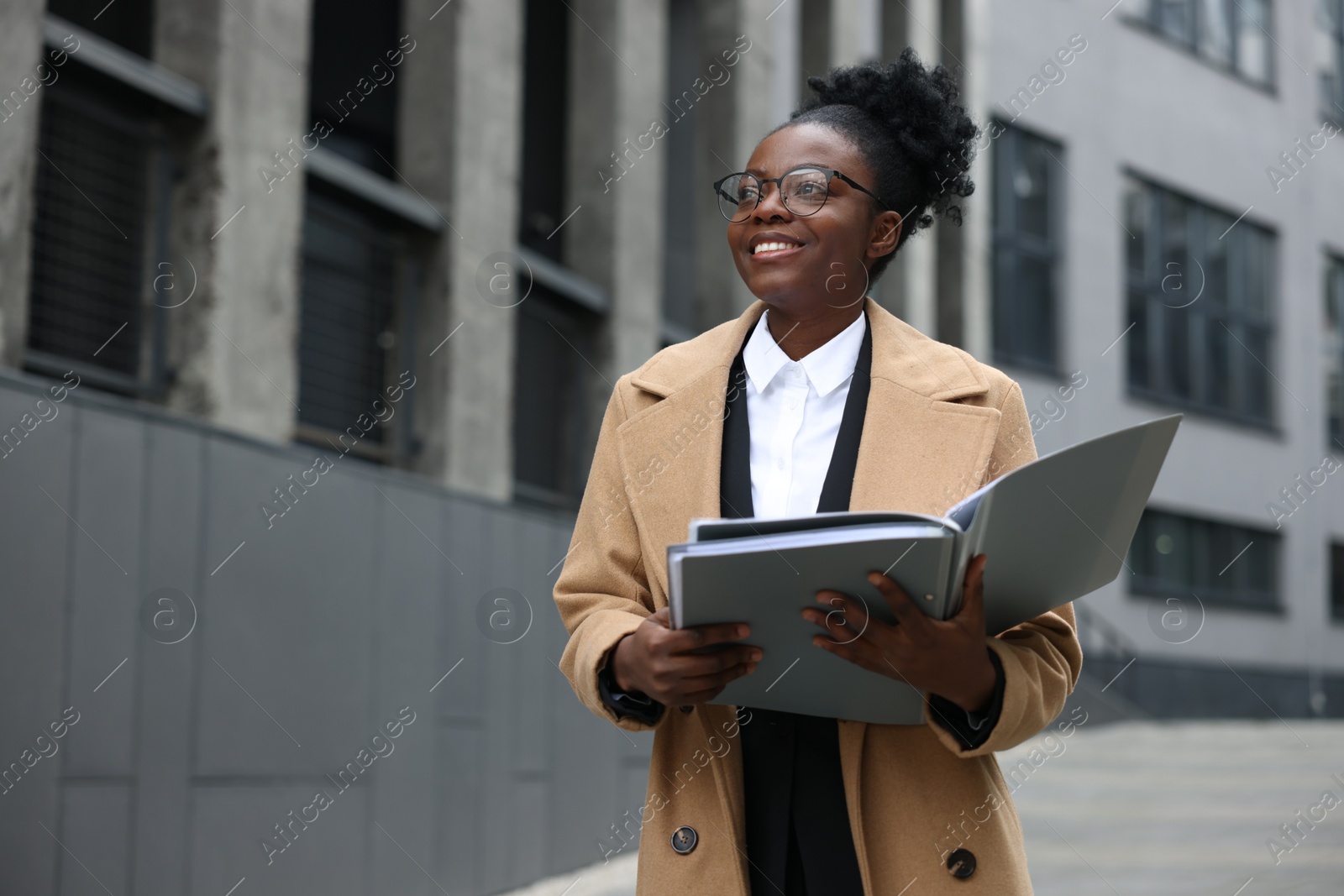 Photo of Happy woman with folders outdoors, space for text. Lawyer, businesswoman, accountant or manager