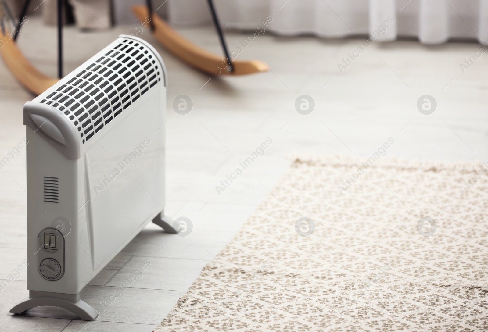 Image of Modern electric heater in stylish room interior. Space for text