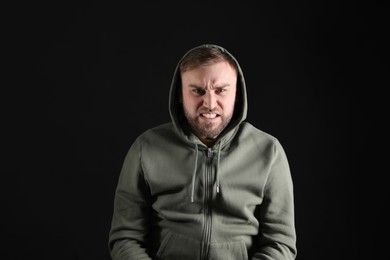 Portrait of emotional young man on black background. Personality concept