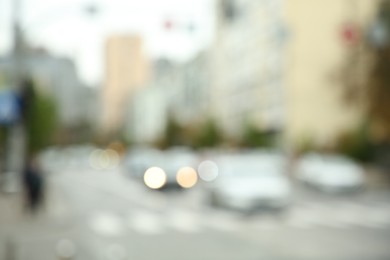 Blurred view of quiet city with buildings and cars on road