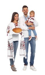 Photo of Happy Ukrainian family in embroidered shirts with korovai bread on white background