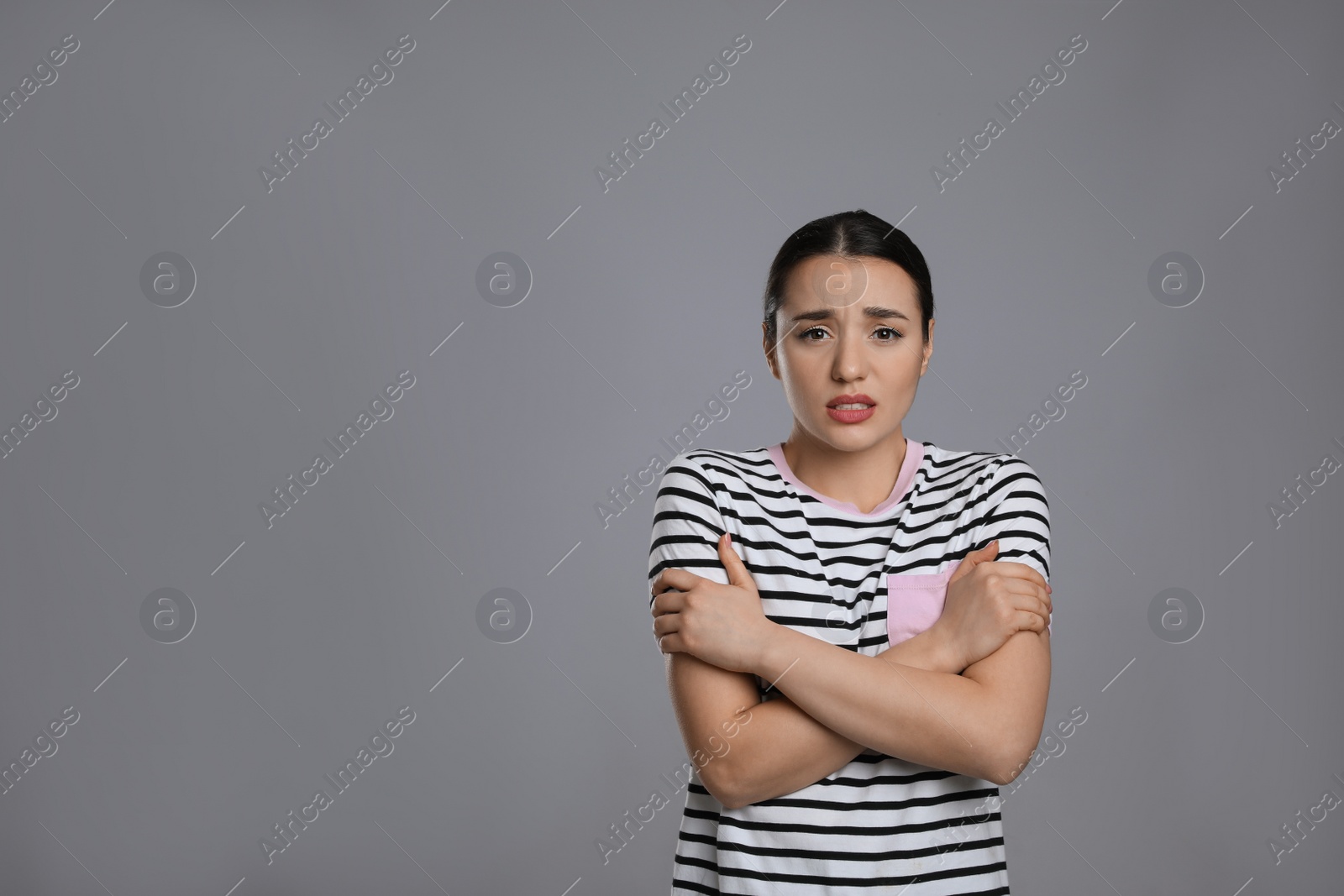 Photo of Young woman suffering from fever on grey background, space for text. Cold symptoms