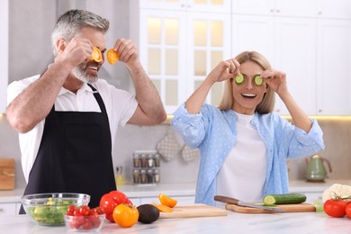 Photo of Happy affectionate couple having fun while cooking together in kitchen