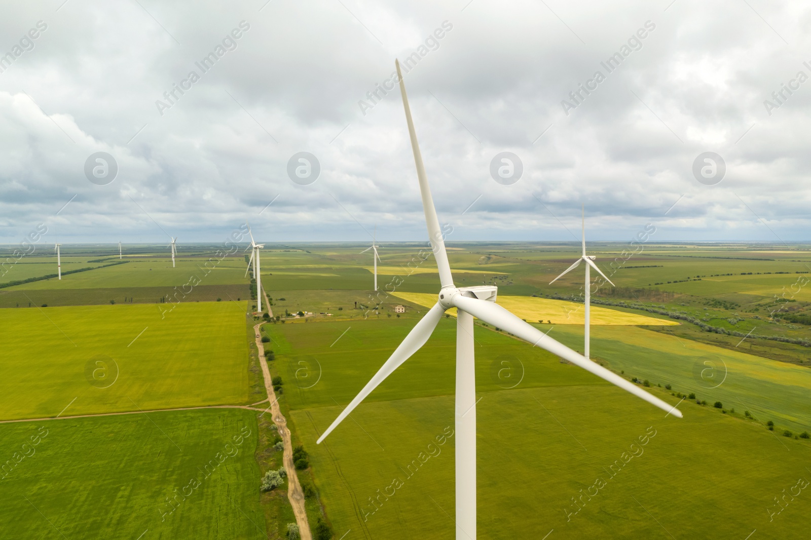 Image of Aerial view of wind turbines in field on cloudy day