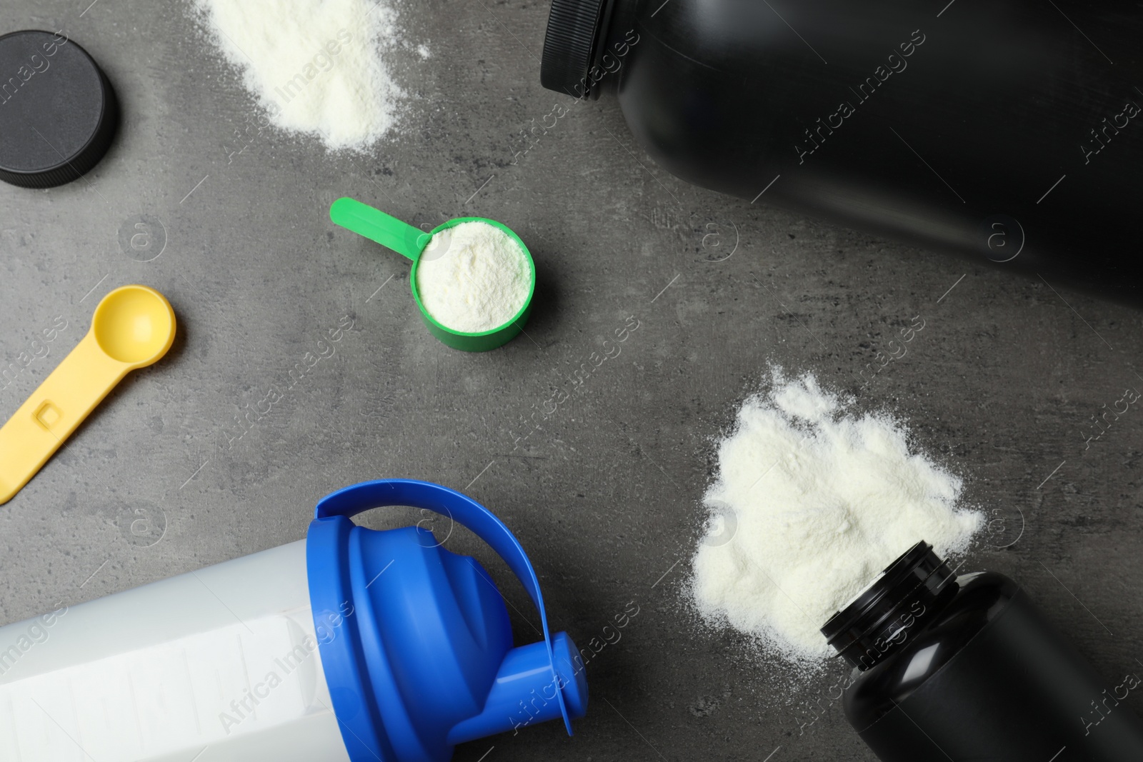 Photo of Flat lay composition with protein powder on grey background