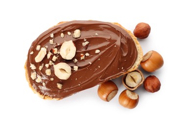 Photo of Bread with tasty chocolate spread and pieces of hazelnuts on white background, top view