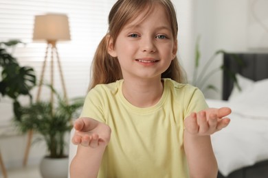 Photo of Cute little girl having video chat indoors, view from web camera