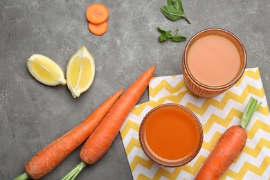 Flat lay composition with carrots and juice on grey table