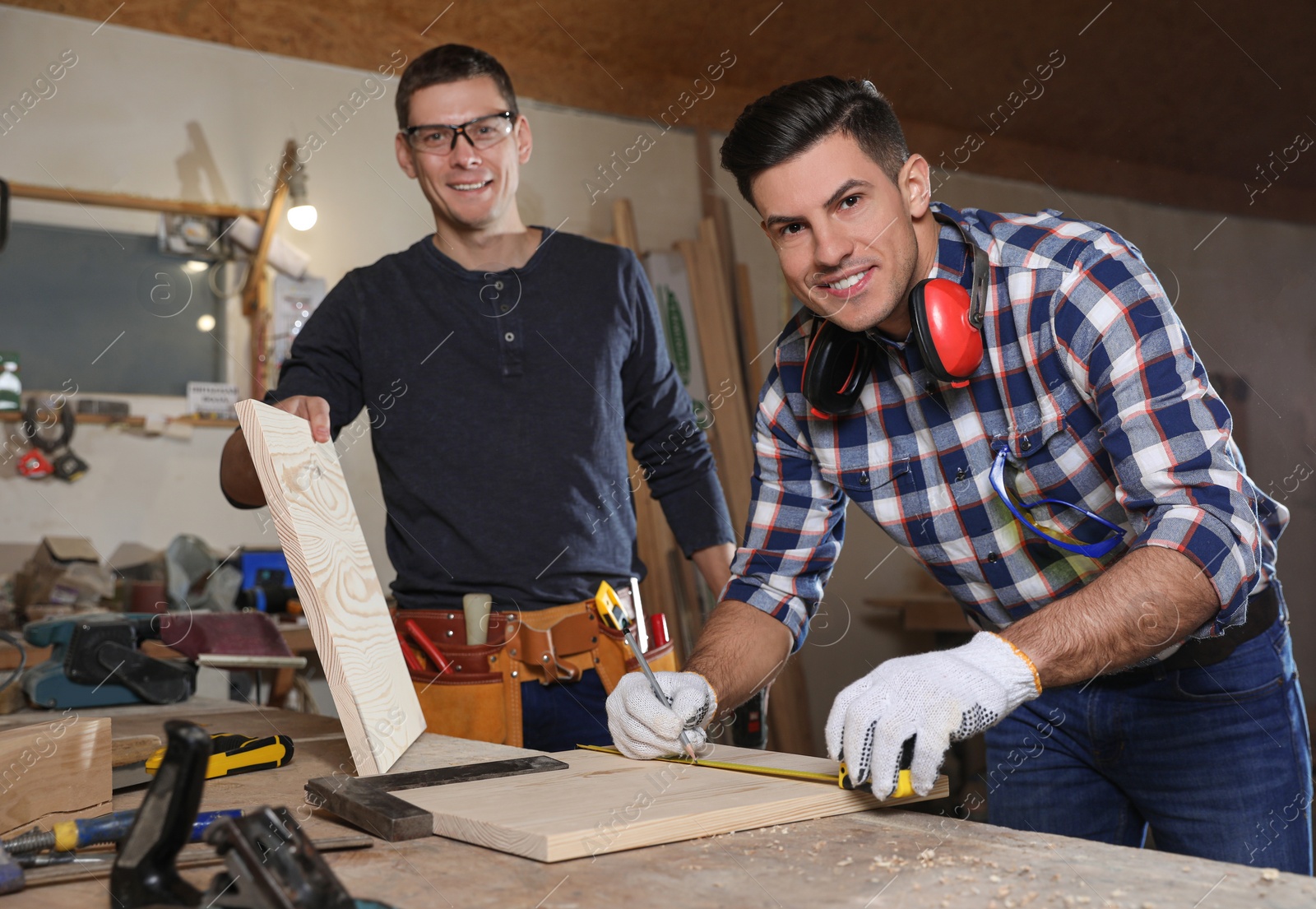 Photo of Professional carpenters working with wooden boards in workshop