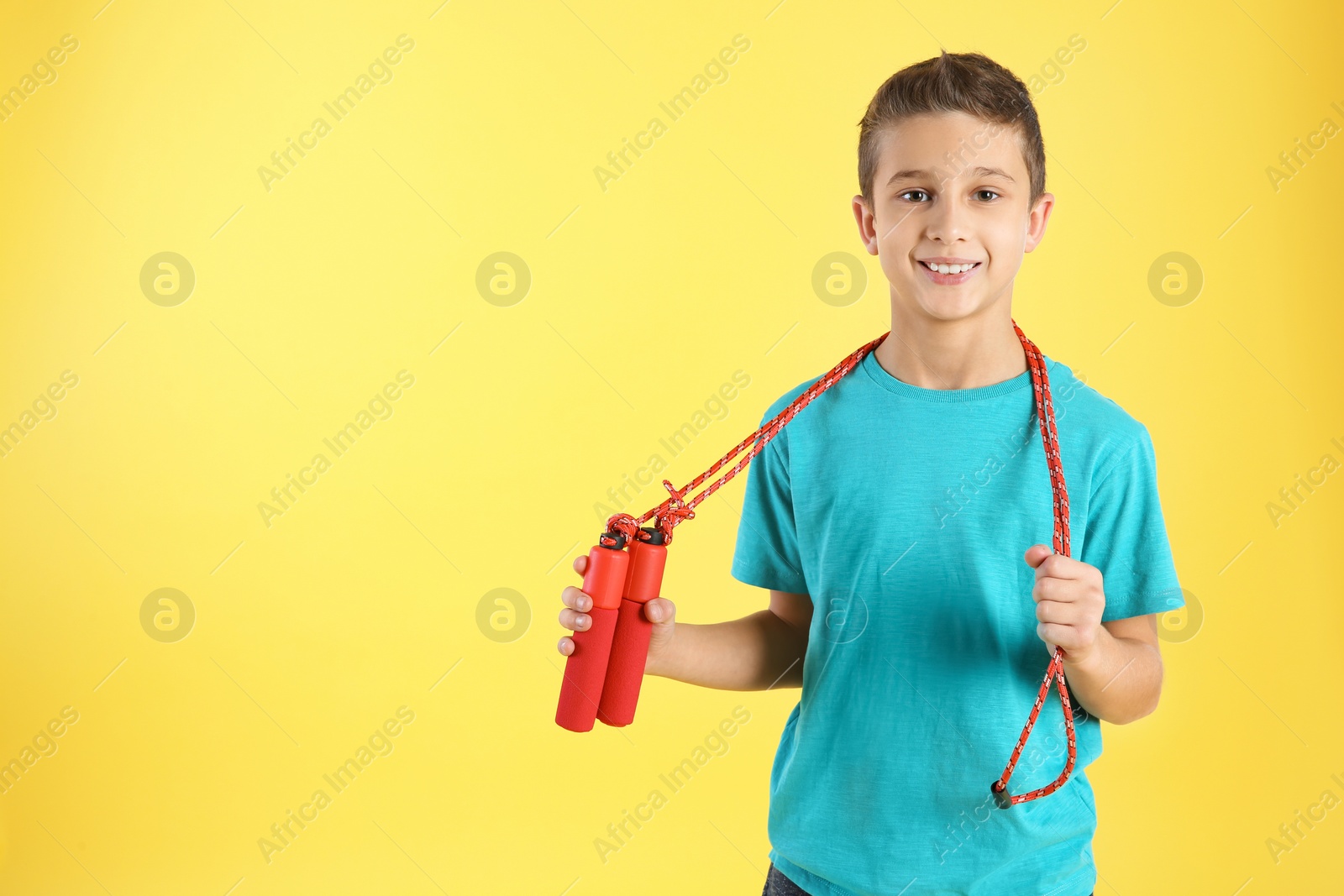 Photo of Boy with jump rope on color background. Space for text