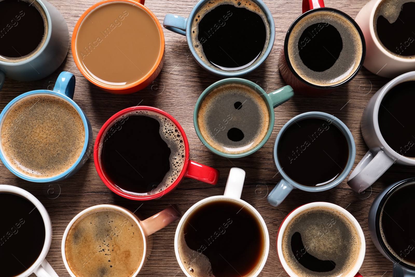 Photo of Cups of hot coffee on wooden table, flat lay