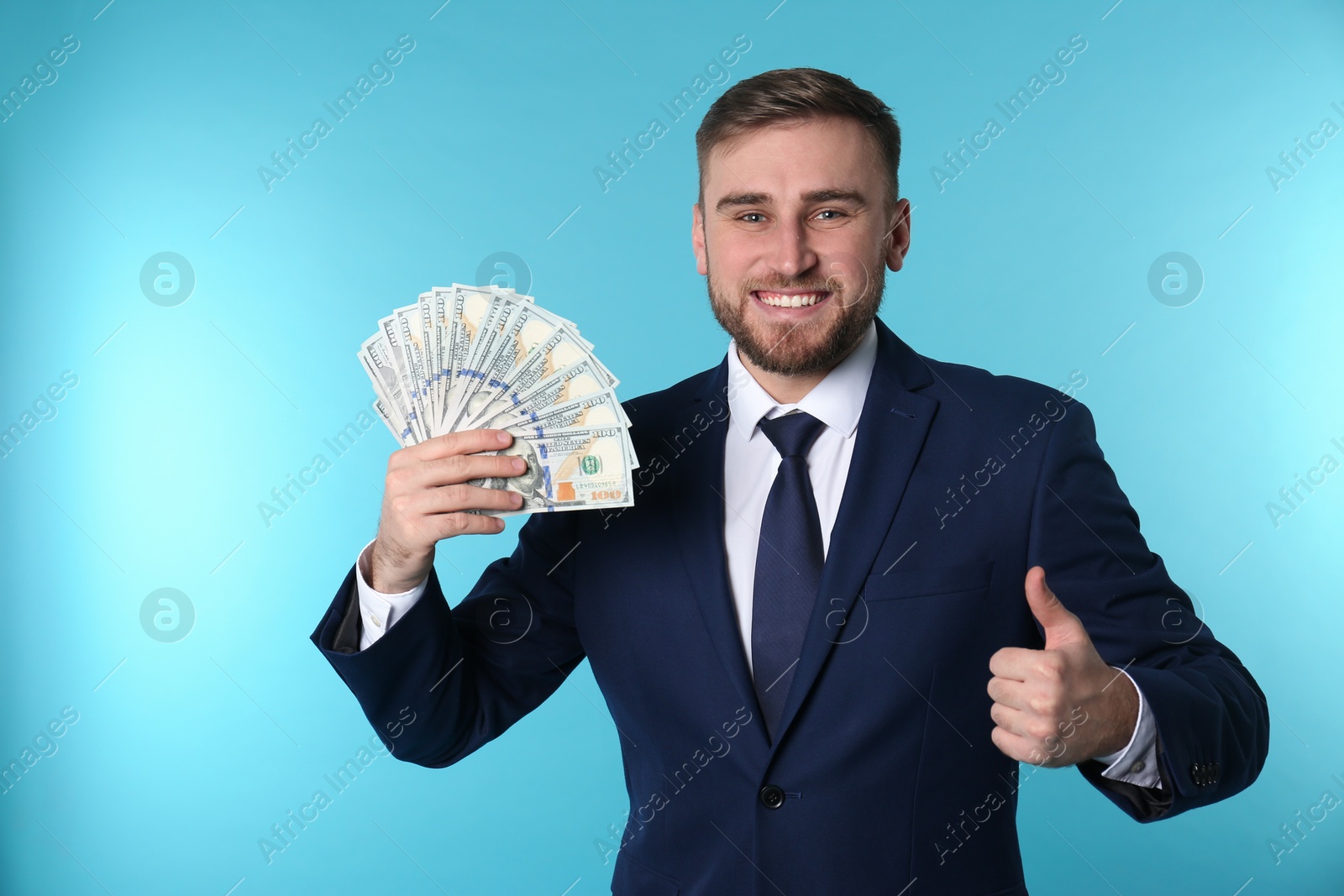 Photo of Portrait of happy young businessman with money on color background