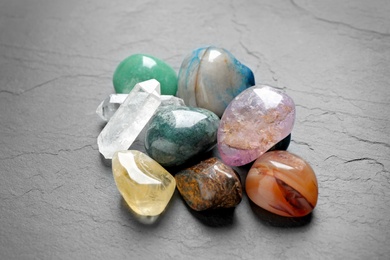 Photo of Pile of different beautiful gemstones on grey background