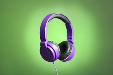 Photo of Stylish headphones with pads on color background