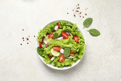 Photo of Delicious salad in bowl on light grey table, top view